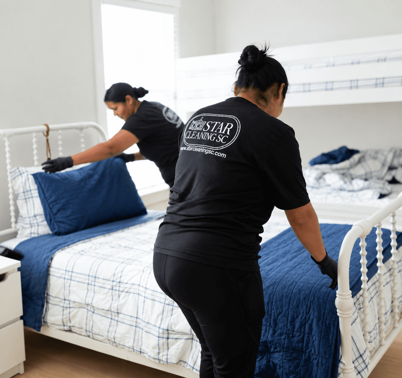 Star Cleaning SC team members making a bed with fresh linens in a Charleston-area home